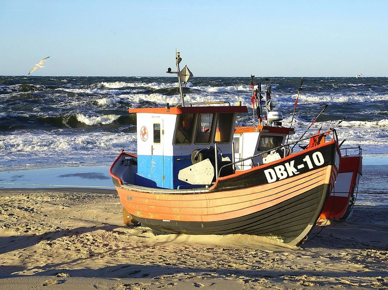 Um caderno de pesca desgastado e um lápis sobre a caixa de equipamento